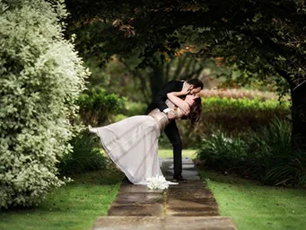 A married couple embrassing, posing for photos around the stunning Inish Beg Estate grounds